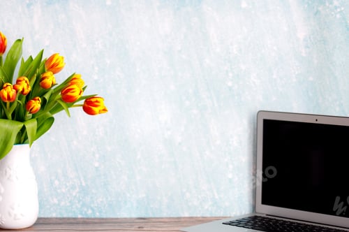 Preview: Office or home workspace with bouquet of colorful tulips on the table. Feminine workspace