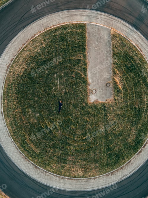 Preview: Businessman lying on traffic island in roundabout