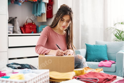 Preview: Woman preparing a box with her used clothes