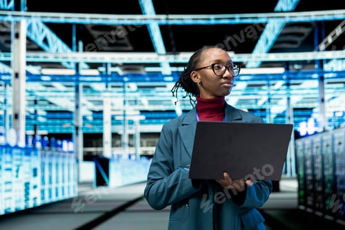 Preview: Data center female technician uses laptop program to conduct security audits