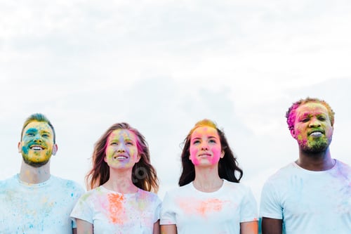 Preview: positive multicultural friends with holi paints on faces