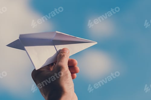Preview: Man's hand holding paper plane, Blue sky background with natural light.