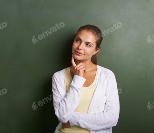 Visualização: Uma adorável jovem professora parada em frente a um quadro negro parecendo atenciosa