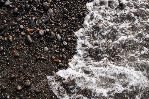 Preview: Foamy wave on the shore of the black volcanic coast.
