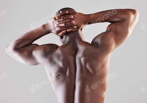 Preview: Rearview shot of a muscular young man posing against a grey background