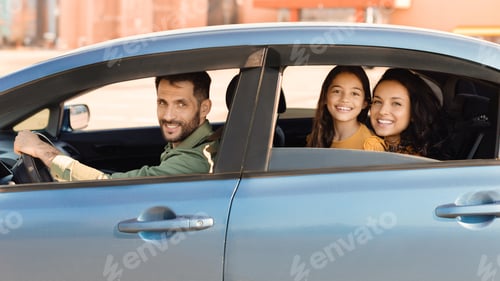 Preview: Happy family in car, father driving with daughter and wife
