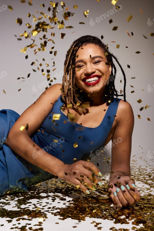 Preview: Stylish young woman with braided hair celebrates joyfully in a studio filled with confetti