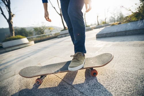 Preview: SkateboardingSkateboarder tying shoelace at outdoors