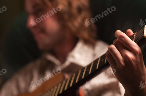 Preview: Young Musician Plays His Acoustic Guitar under Dramatic Lighting.