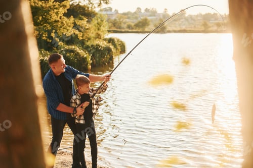Preview: Some food to eat. Father and son on fishing together outdoors at summertime