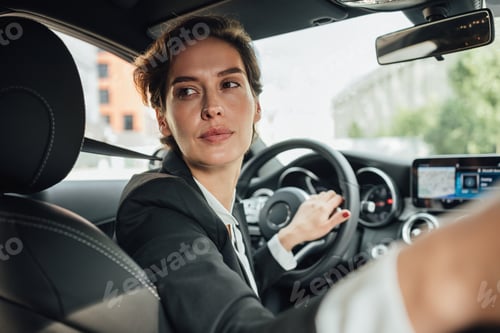 Preview: Portrait of caucasian businesswoman driving a car in reverse looking on back window