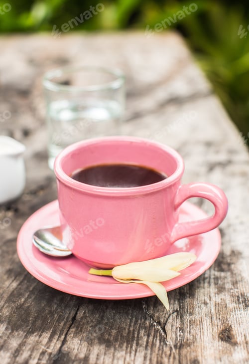 Preview: Pink cup of coffee on wooden table