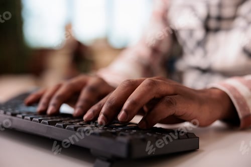 Preview: Closeup of african american male influencer writing article for online blog on computer keyboard