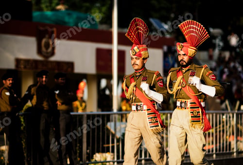 Preview: Two uniformed soldiers marching in a parade, adorned with decorative headgear and official regalia.
