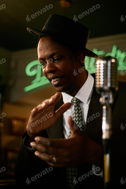 Preview: Smiling Black Male Singer Wearing Hat Performing Music in Jazz Club