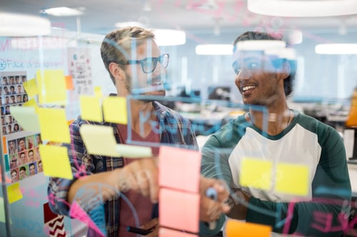 Preview: Smiling creative business team reading sticky notes
