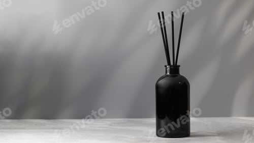 Preview: Bamboo sticks in a black bottle with indoor perfumes. Glass diffuser with fragrance. Copy space