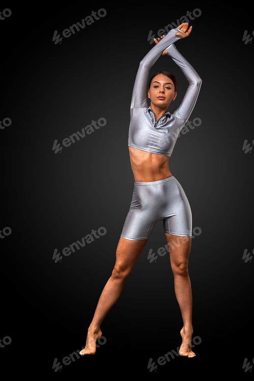 Preview: sexy brunette girl with a slim figure in leggings posing in studio on a black background