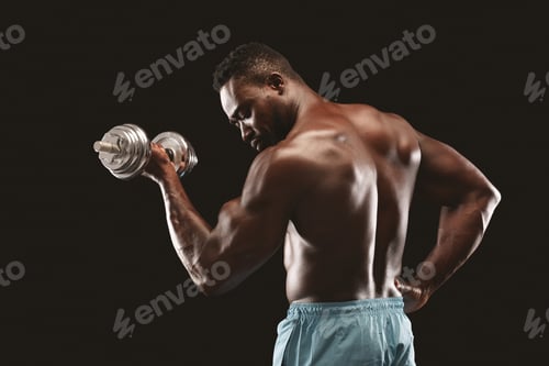 Preview: Side view of black bodybuilder doing single arm dumbbell curl