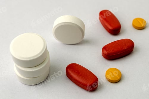 Preview: Several types of pills or tablets, maybe narcotic, antibiotic or aspirin, on light background.
