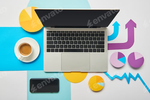 Preview: top view of laptop with cup of coffee, paper charts and graph, pointers on white background