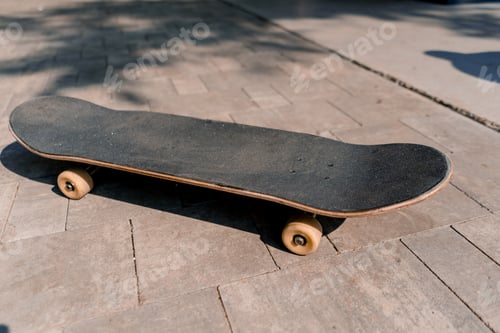 Preview: A close-up of skateboard that lies on the path in the park the concept of adrenaline craving