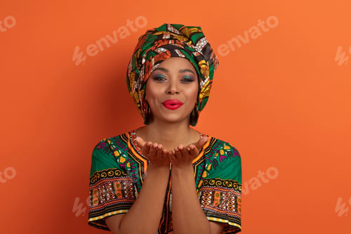 Preview: Flirtatious beautiful african lady sending fly kiss at camera