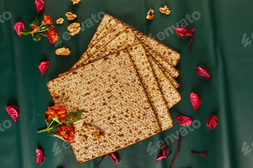 Preview: Matzo bread stack with nuts, flowers on table, creative arts display