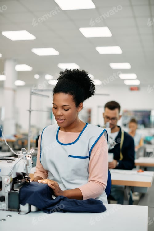 Preview: Young black woman working as dressmaker in textile factory.