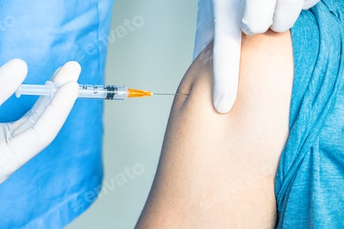 Preview: Nurse or medical staff in white gloves putting the vaccine with a needle in the arm for Covid-19