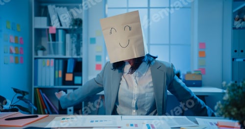 Preview: Young Asian businesswoman sit on desk wear draw happy mask paper craft bag dance feel enjoy.