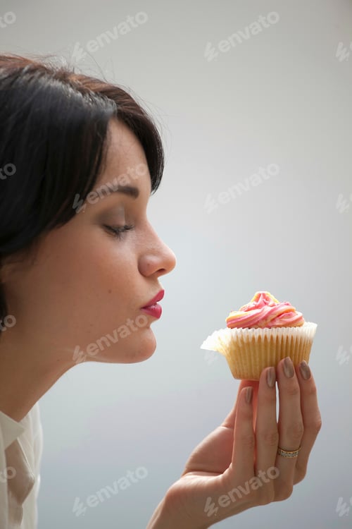 Preview: Close up of woman eating cupcake