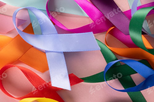 Preview: Extreme close-up of various multicolored awareness ribbons on pink background, copy space