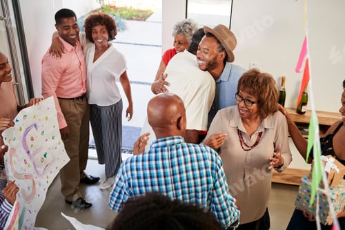 Preview: Black family members embracing at a surprise party, elevated view