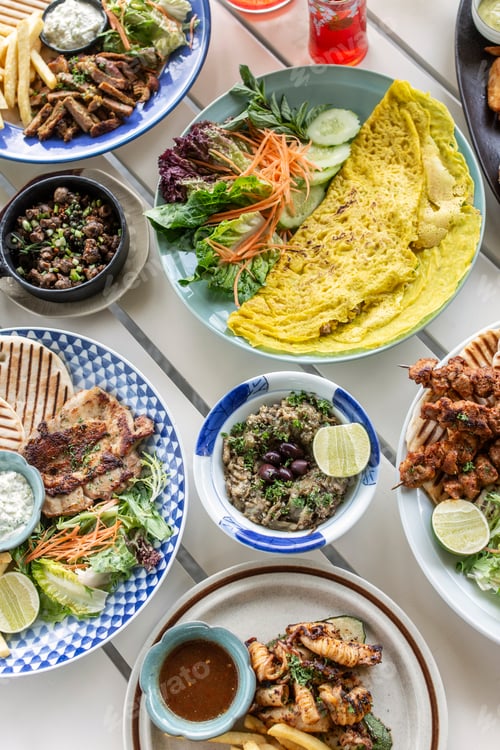 Preview: many different mediterranean food dishes on restaurant table in greece