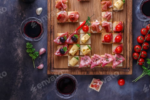 Preview: Close view of small tapas topped with jamon, cured meat and cheese