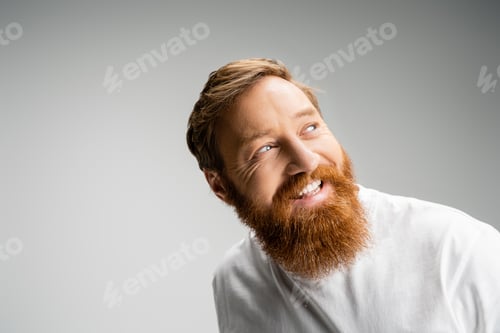 Preview: Happy and bearded man in t-shirt looking away isolated on grey
