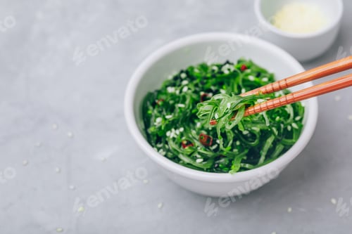 Preview: Seaweed Salad with sesame seeds in bowl on gray concrete stone background