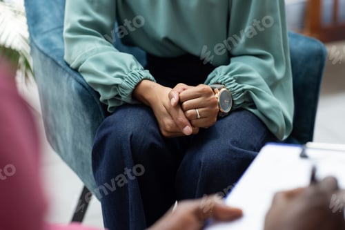 Preview: Midsection of biracial female patient attending therapy with african american male therapist