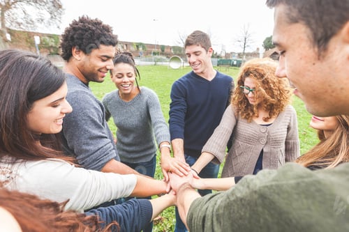 Preview: Multiracial group of friends with hands in stack