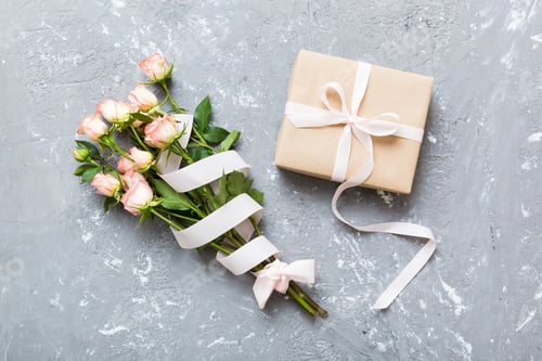 Preview: design concept with pink rose flower and gift box on colored table background