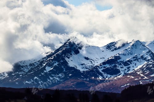 Preview: Scenic landscape featuring snowy mountains under a dramatic sky in Isle of Skye, Scotland, UK