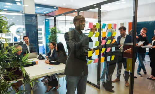Preview: Multiracial colleagues working inside business office with glass walls