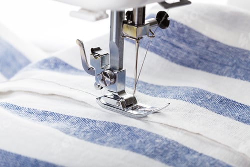 Preview: Sewing machine stitching blue and white striped fabric during afternoon crafting session
