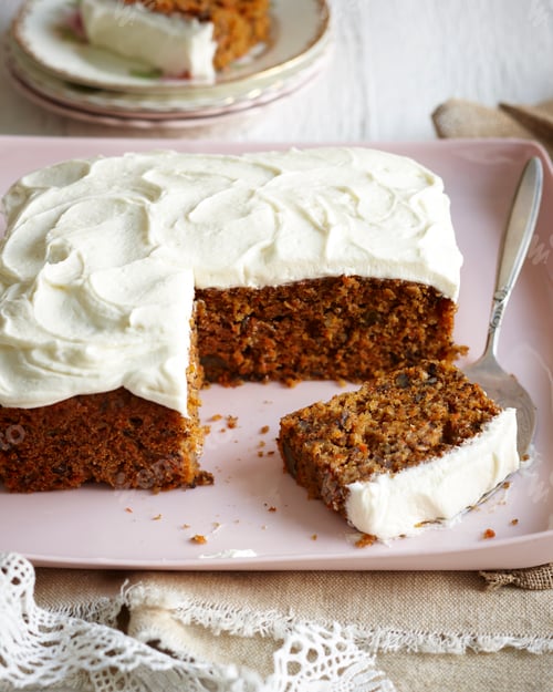 Preview: Slice of carrot cake with cream cheese frosting on a pink plate.