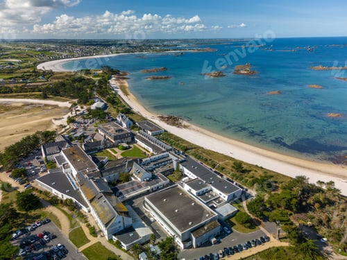 Preview: Aerial view of a coastal town with beach and buildings.