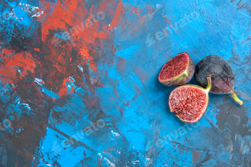 Preview: Top view of split and full fresh black mission figs on the left side on blue background