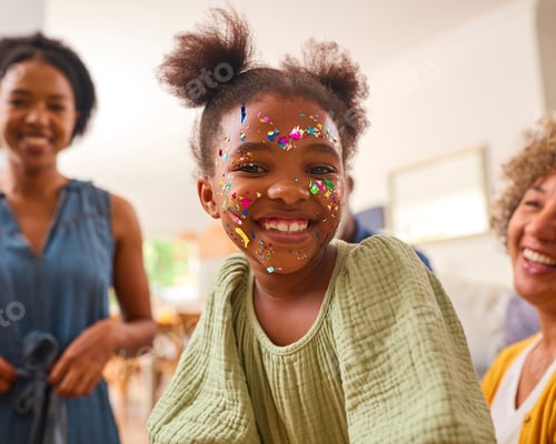 Preview: Granddaughter With Face Decorated With Party Glitter With Grandmother With Mother At Home Together