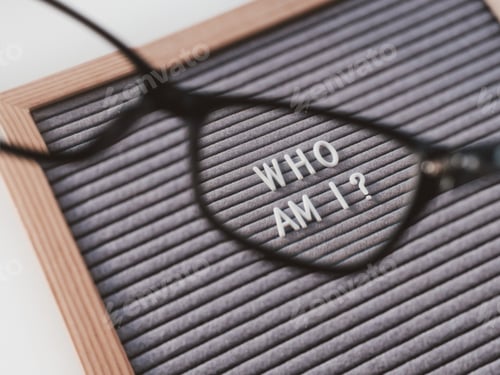 Preview: Top view on letter board with words WHO AM I through eyeglasses. psychological self-regulation