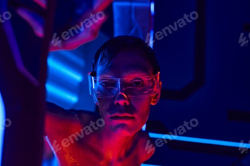 Preview: scientific breakthrough, alien in goggles looking at camera near high-tech device in science center